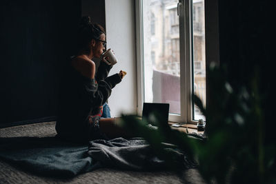 Side view of woman eating at home