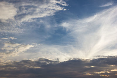 Low angle view of sunlight streaming through clouds