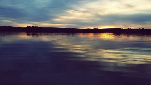 Scenic view of lake against sky at sunset