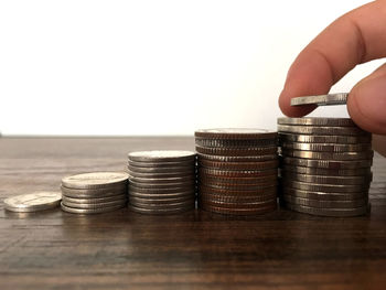 Close-up of hand holding stack of objects on table