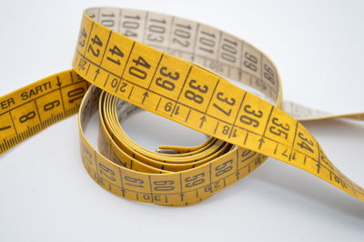 High angle view of measuring tape against white background