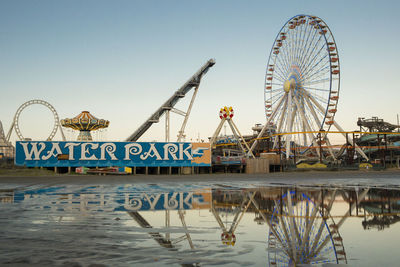 Ferris wheel in city against clear sky