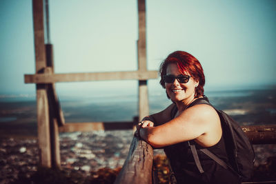 Portrait of young woman in sunglasses against sea