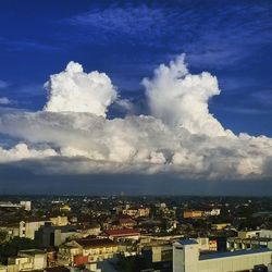 View of cityscape against cloudy sky