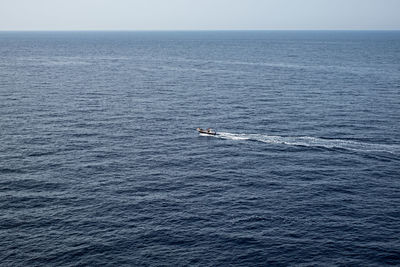 Scenic view of sea against sky with motorboat in the middle