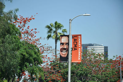 Low angle view of text on street light against sky