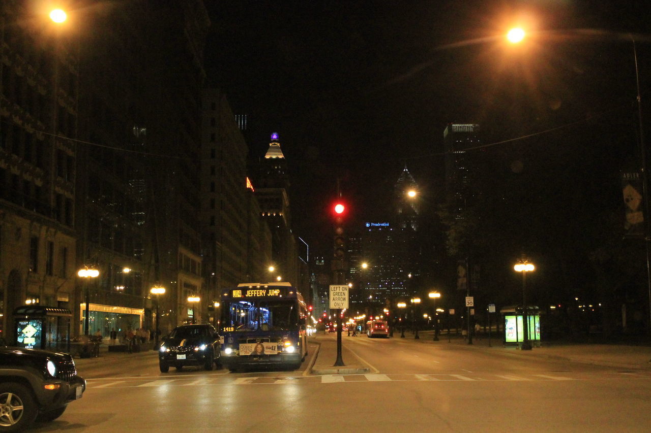 CARS ON ILLUMINATED STREET AT NIGHT