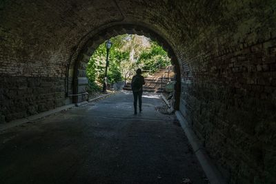 Rear view of man walking in archway