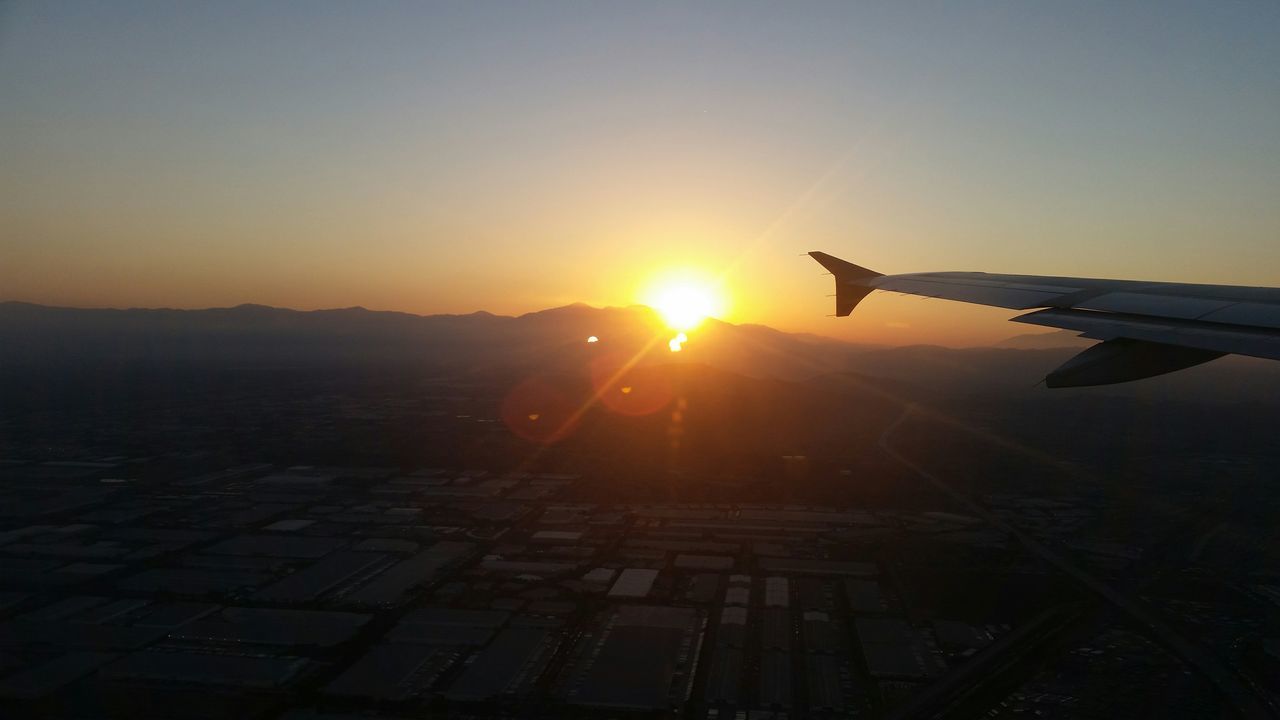 airplane, sunset, aircraft wing, air vehicle, transportation, mode of transport, sun, flying, travel, part of, public transportation, sunlight, cropped, on the move, orange color, mid-air, scenics, landscape, journey, sky