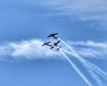 Low angle view of airshow against blue sky