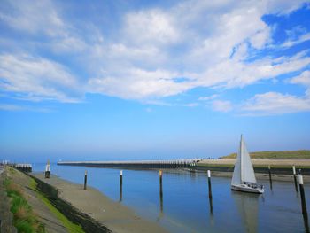 Sailboats in sea against sky