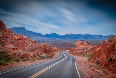 Road amidst mountains against sky