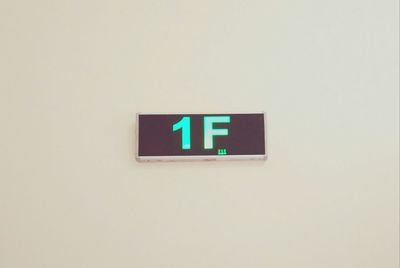 Close-up of information sign against wall