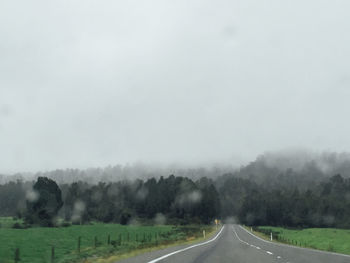 Road amidst field against sky