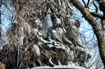 Low angle view of statue against bare trees