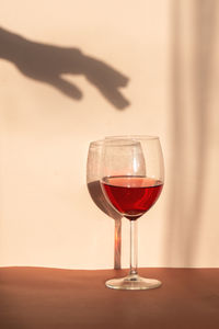 Glass of wine with shadow of hand, retro style