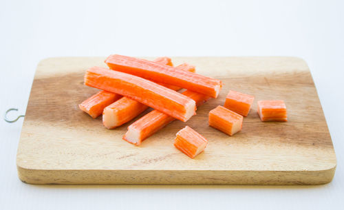 Close-up of chopped bread on cutting board against white background