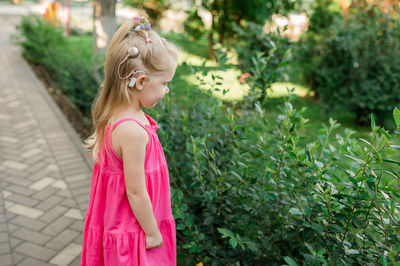 Young woman standing against plants