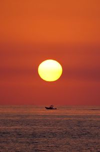 Scenic view of sea against orange sky