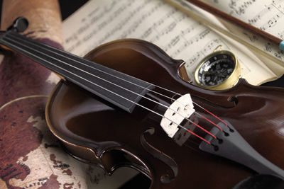 High angle view of violin and sheet music on table