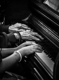 Cropped hand of woman playing piano