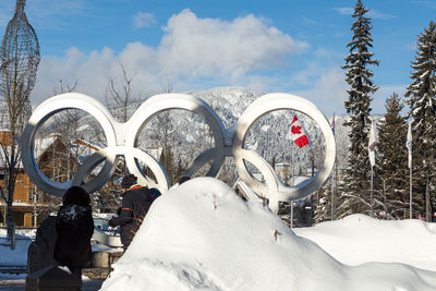 Rear view of people in snow against sky