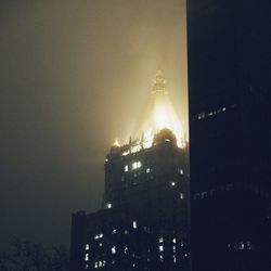 Low angle view of modern building against sky at night