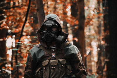 Person wearing mask in forest during autumn