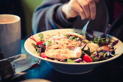 Close-up of person eating food served on table