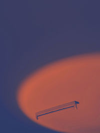 Low angle view of airplane against clear sky during sunset