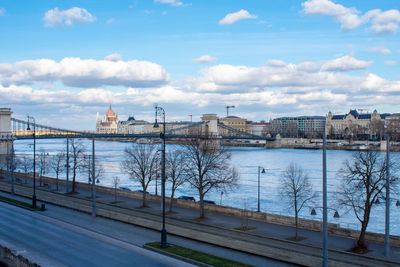 Bridge over river against cloudy sky