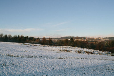 Snow on field against sky during winter