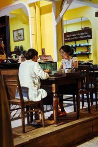 Woman sitting on table in restaurant