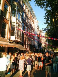 People walking on street against buildings in city