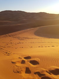 Sand dunes in desert against clear sky