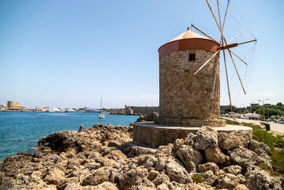 Old windmill at mandraki harbour in rhodes city on rhodes island, greece