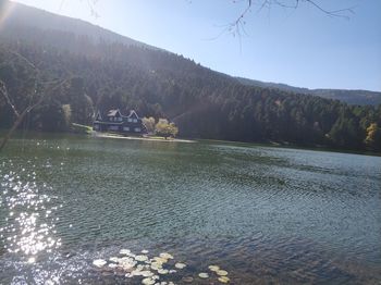 Scenic view of lake by mountains against sky