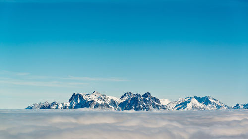 Scenic view of snowcapped landscape against blue sky