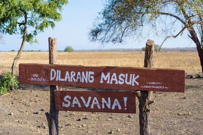 Information sign on tree trunk against sky