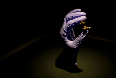 Midsection of person standing against black background