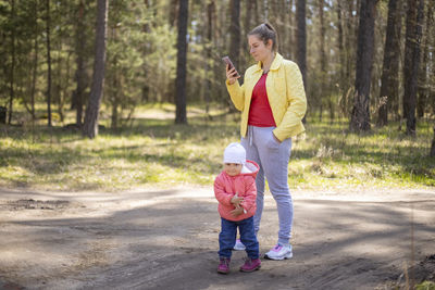 Full length of mother and daughter standing on tree