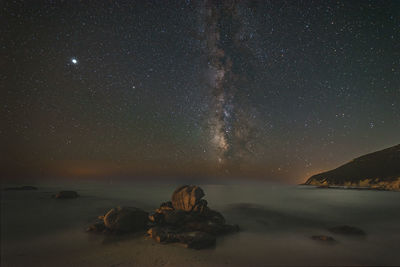 Scenic view of sea against star field at night