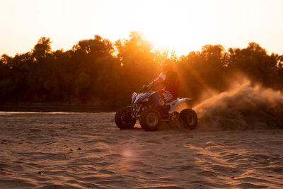 Man riding motorcycle on land against sky