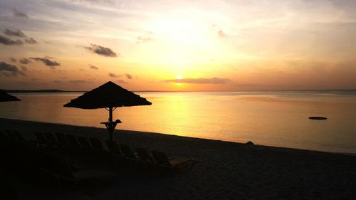 Silhouette beach against sky during sunset