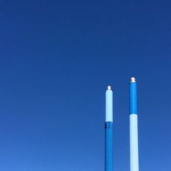 Low angle view of smoke stack against blue sky