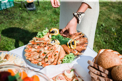 Midsection of woman having food in yard