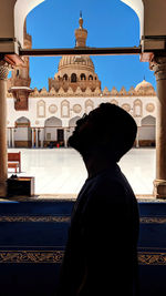 Rear view of man standing against building