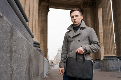 Young man walking down street, autumn or winter cold day. outdoors, outside.