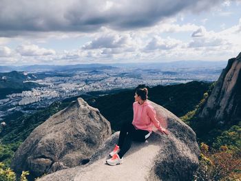 Man on rock against sky