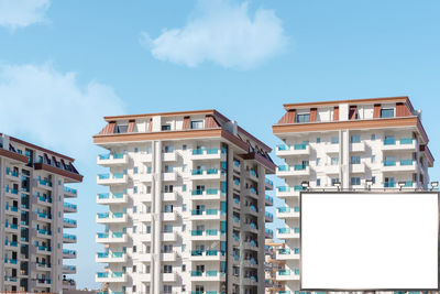 A blank billboard mockup against the backdrop of a residential area in southern turkey.